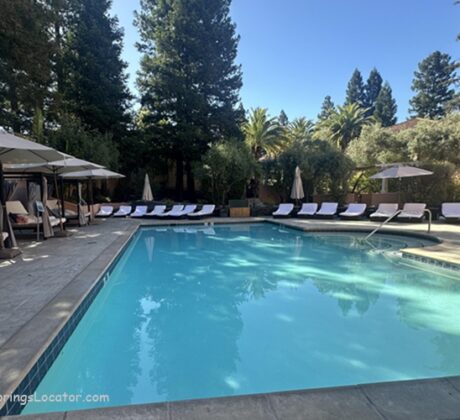 Fairmont Sonoma Mission Inn & Spa in California: The picture "Fairmont Sonoma Mission Inn & Spa in California spa pool with loungers" displays a tranquil outdoor pool area lined with white-cushioned lounge chairs and umbrellas, set among trees and greenery for a relaxing atmosphere.